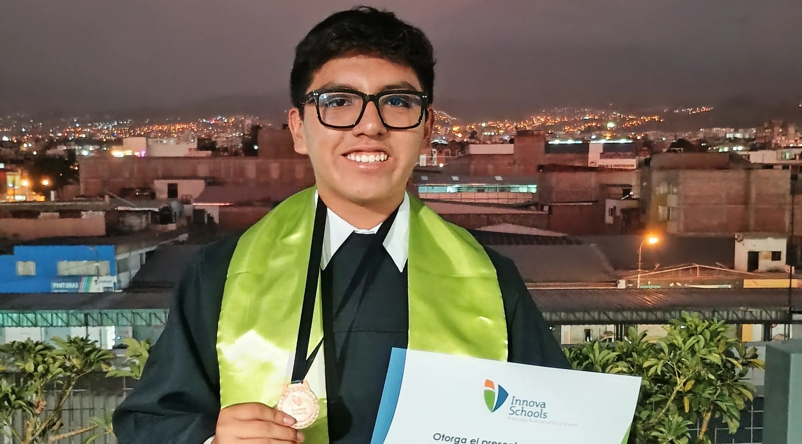 Alejandro Moquillaza, egresado de Innova Schools, sonriendo y sosteniendo su diploma de egreso.